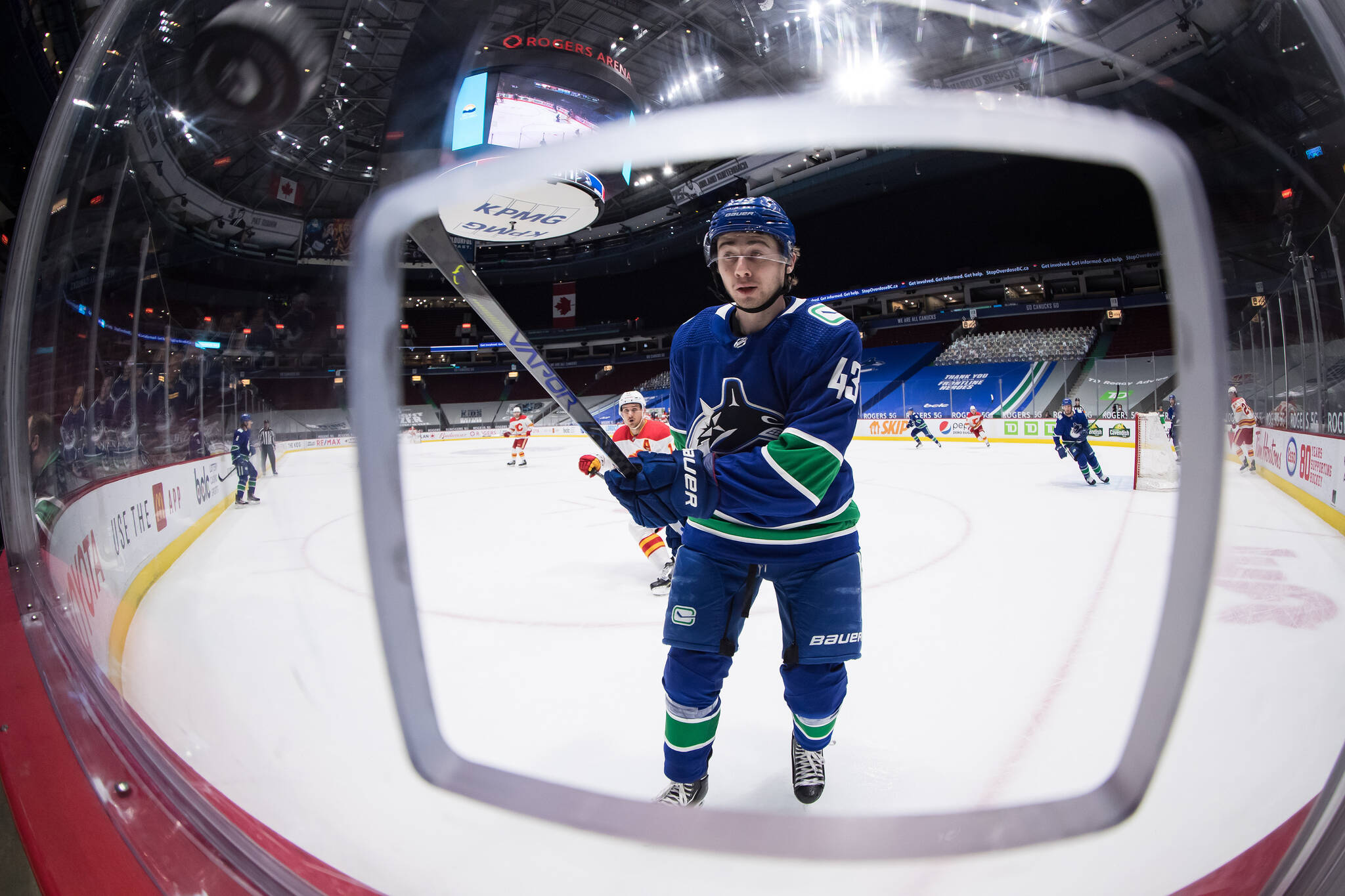 Vancouver Canucks’ Quinn Hughes reaches for the puck as it bounces off the glass after being shot around the boards during first period NHL hockey action against the Calgary Flames in Vancouver, on Tuesday, May 18, 2021. THE CANADIAN PRESS/Darryl Dyck