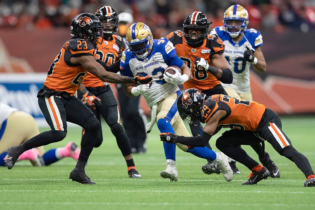 Winnipeg Blue Bombers’ Andrew Harris, centre, is tackled by B.C. Lions’ Anthony Thompson (23) and Jalon Edwards-Cooper (29) during the first half of a CFL football game in Vancouver, on Friday, October 1, 2021. THE CANADIAN PRESS/Darryl Dyck