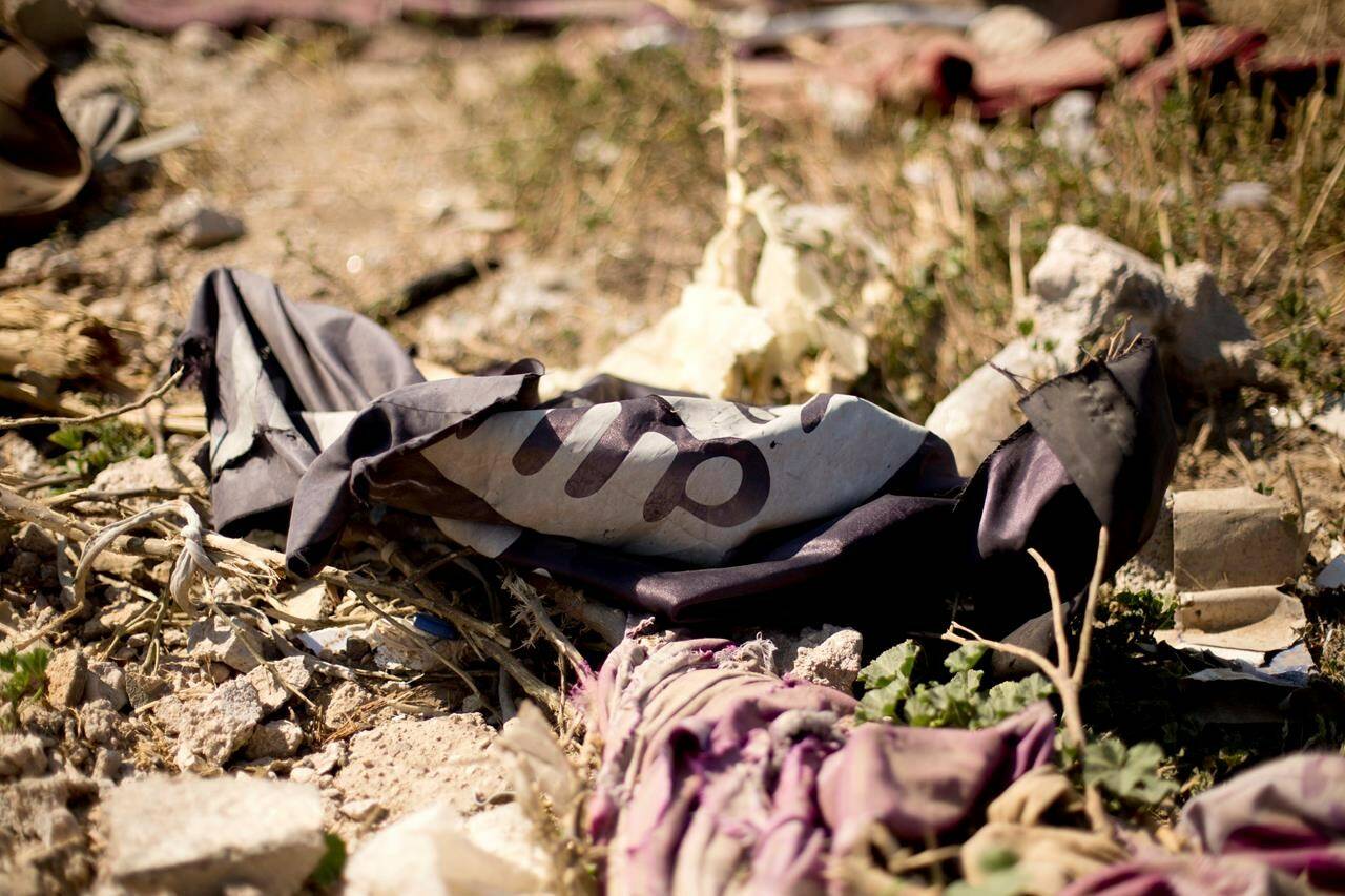 An Islamic State militant flag lies in a tent encampment after U.S.-backed Syrian Democratic Forces (SDF) fighters took control of Baghouz, Syria, Saturday, March 23, 2019. THE CANADIAN PRESS/AP-Maya Alleruzzo