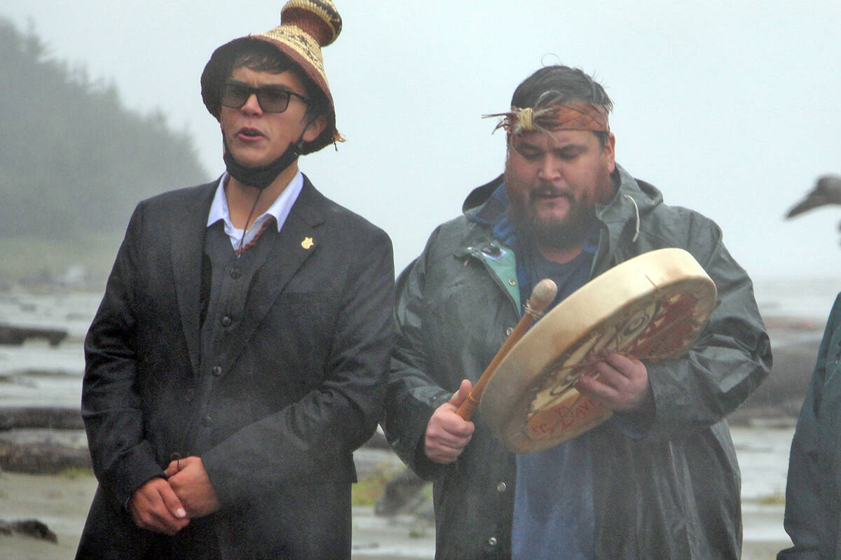 Tla-o-qui-aht First Nation members Timmy Masso and Hjalmer Wenstob lead a gathering outside the Tofino beachfront property Prime Minister Justin Trudeau is currently staying in to demand an apology on a rainy Saturday evening. (Andrew Bailey photo)