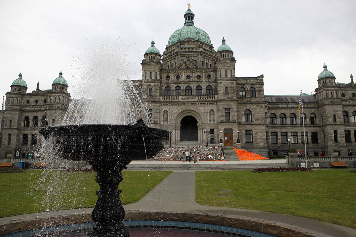 Orange shirts, shoes, flowers and messages are on display on the steps outside the legislature in Victoria, B.C., on Saturday, June 12, 2021 in honour of the 215 children whose remains have been discovered buried near the former Kamloops Indian Residential School. THE CANADIAN PRESS/Chad Hipolito