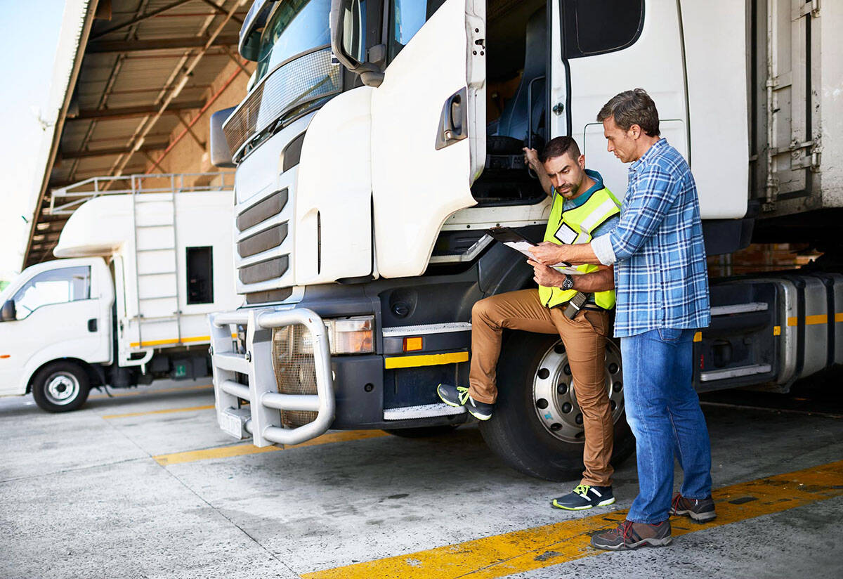 Two employees who drive for work review a safety checklist before getting behind the wheel. (iStock photo).