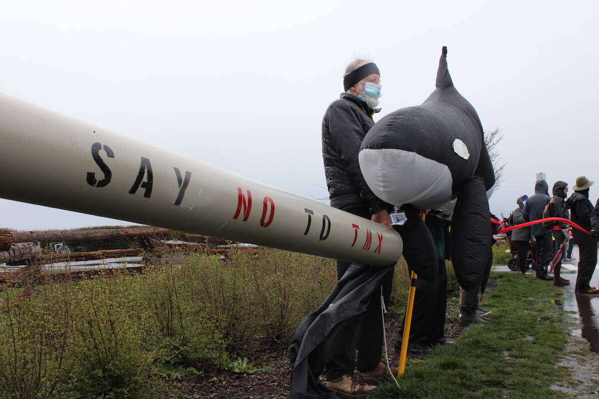 Demonstrators line the Dallas Road walkway in Victoria B.C. on March 28 to protest the Trans Mountain pipeline expansion. (Jake Romphf/News Staff)