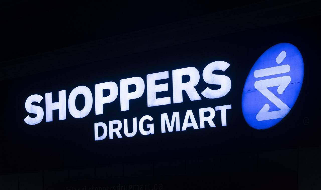 A Shoppers Drug Mart sign is illuminated on a store Tuesday March 30, 2021 in Ottawa. Ontario and Shoppers Drug Mart are partnering to distribute free menstrual products in schools. THE CANADIAN PRESS/Adrian Wyld