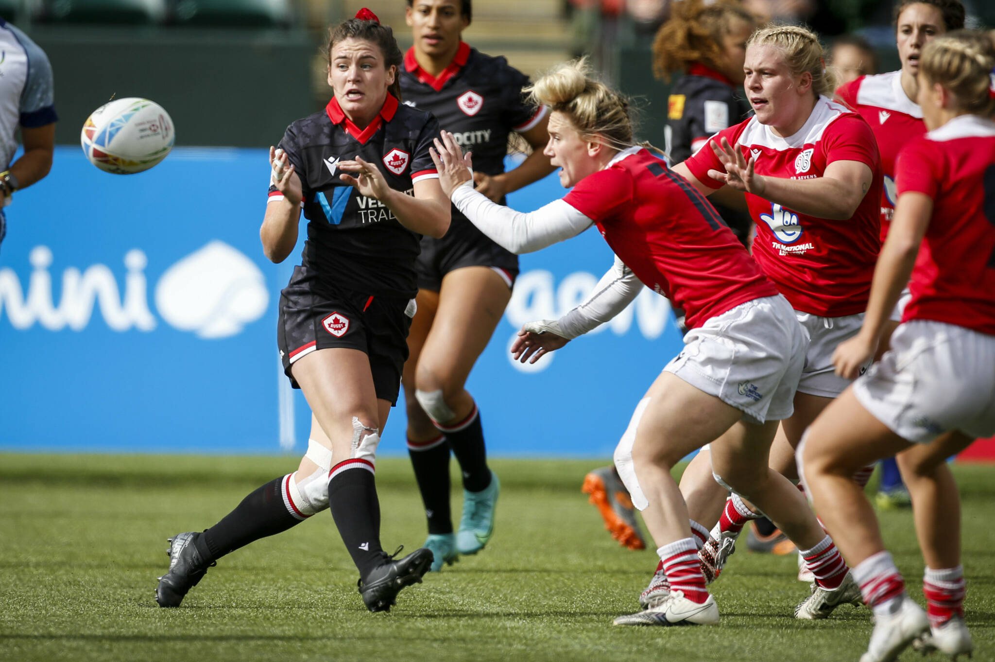 Canada's Alysha Corrigan, front left, passes the ball as Britain's Megan Jones grabs her during a women's HSBC Canada Sevens rugby match in Edmonton, Alberta, Saturday, Sept. 25, 2021. (Jeff McIntosh/The Canadian Press)