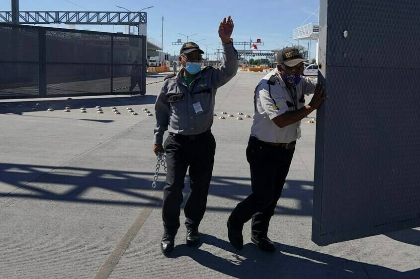 Mexican security officers open the main gate of the international border bridge that connects Del Rio, Texas and Ciudad Acuna, Mexico, after its partial reopening Saturday, Sept. 25, 2021. A new trilateral poll suggests U.S. residents are far more worried about reopening the land border with Mexico than they are about letting Canadians drive into the country.THE CANADIAN PRESS/AP/Fernando Llano