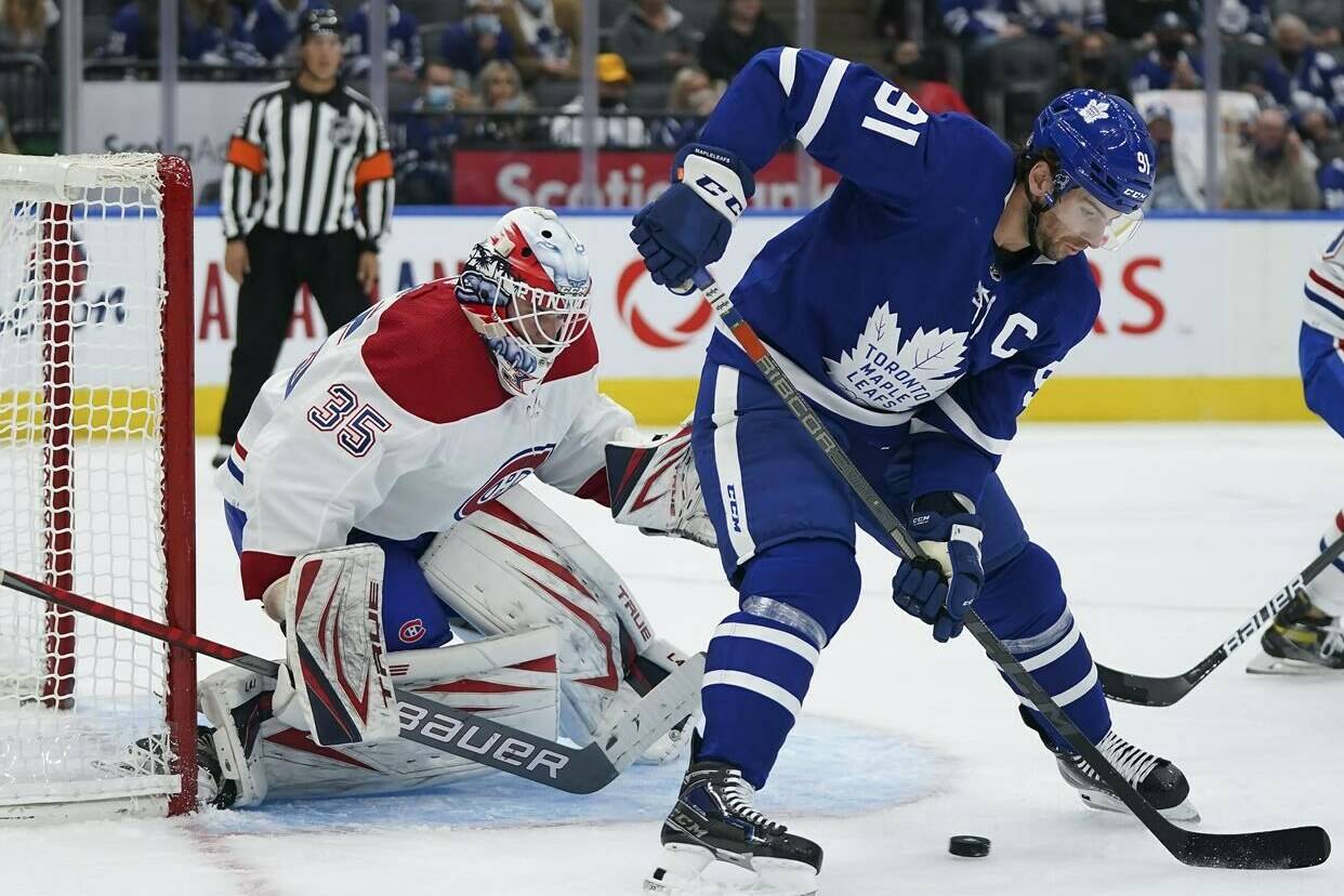 Toronto Maple Leafs forward John Tavares (91) tries to tip the puck past Montreal Canadiens goaltender Sam Montembeault (35) during first period NHL pre-season hockey action in Toronto on Tuesday, October 5, 2021. THE CANADIAN PRESS/Nathan Denette