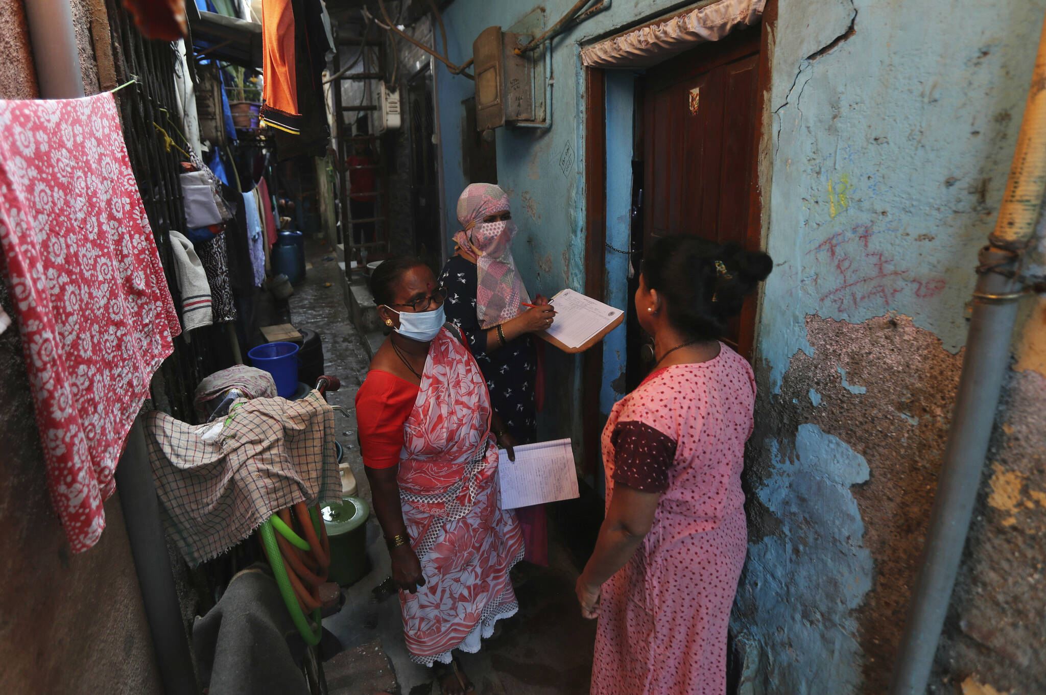 Health workers screen people for tuberculosis and leprosy in Dharavi, one of Asia’s biggest slums, in Mumbai, India, Tuesday, Dec. 1, 2020. (AP Photo/Rafiq Maqbool)