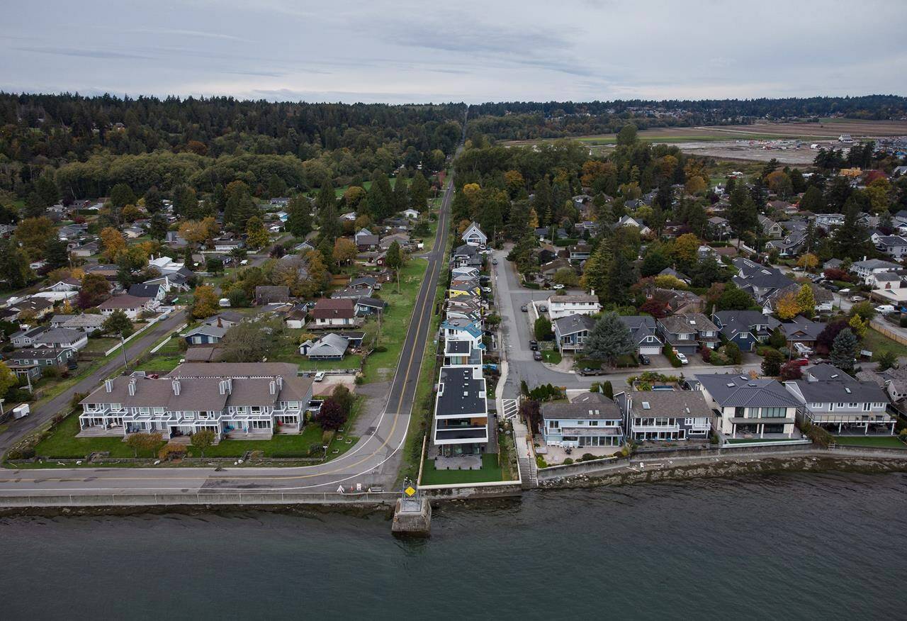 Homes in Delta, B.C., right, and Point Roberts, Wash., left, are separated by the Canada-U.S. border which is just north of Roosevelt Way, centre, in Point Roberts, as seen in an aerial view on Wednesday, October 13, 2021.THE CANADIAN PRESS/Darryl Dyck