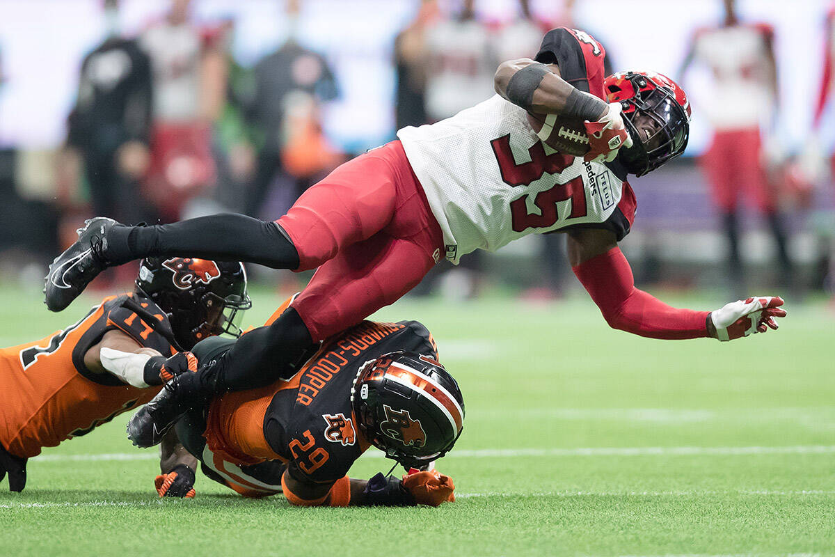 Calgary Stampeders’ Ka’Deem Carey (35) is upended by B.C. Lions’ Jalon Edwards-Cooper (29) as he runs the ball during the second half of a CFL football game in Vancouver, on Saturday, October 16, 2021. THE CANADIAN PRESS/Darryl Dyck