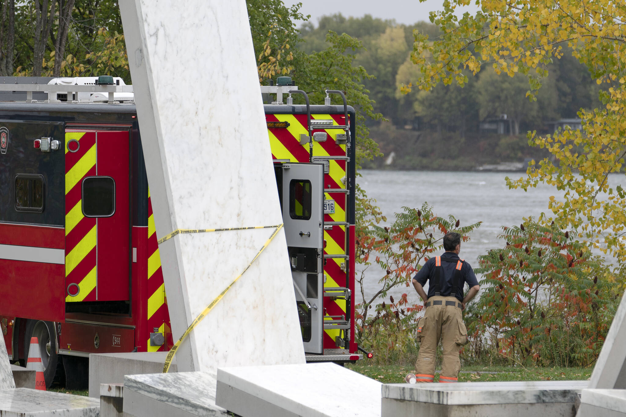 A firefighter stands on the shoreline of the St.Lawrence River Monday, October 18, 2021, where a firefighter drowned during a rescue operation in Montreal. THE CANADIAN PRESS/Ryan Remiorz