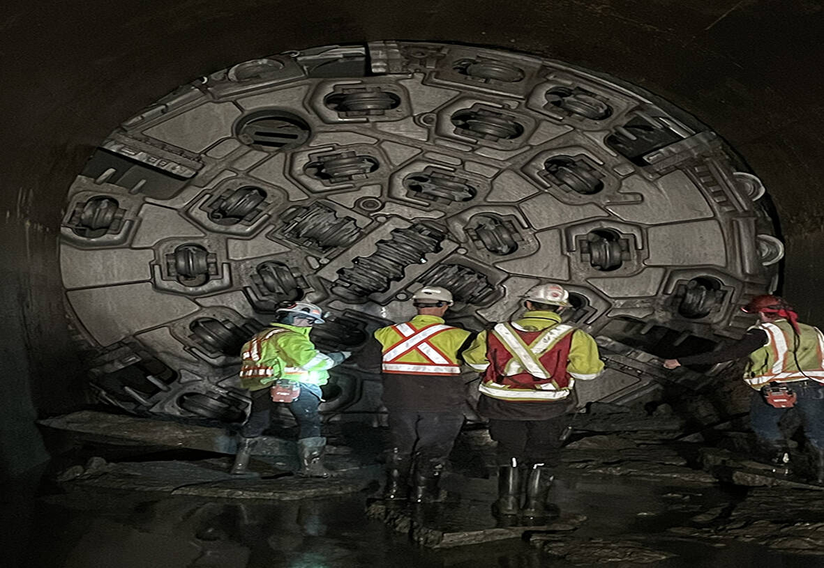Workers standing near the boring machine which is 190-metres-long with a diameter of more than six metres. (Photo Supplied/Rio Tinto)