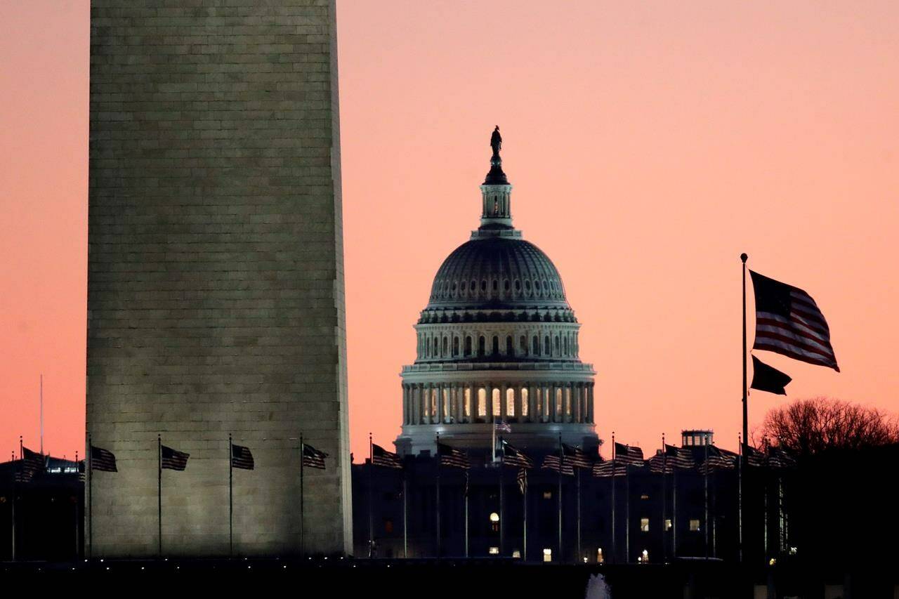 The U.S. Capitol building, centre, is seen next to the bottom part of the Washington Monument, left, before sunrise on Capitol Hill in Washington, Thursday, Dec. 19, 2019. A new survey suggests a majority of Canadians are satisfied with the state of their democracy, a stark contrast with their southern neighbours. THE CANADIAN PRESS/AP, Julio Cortez