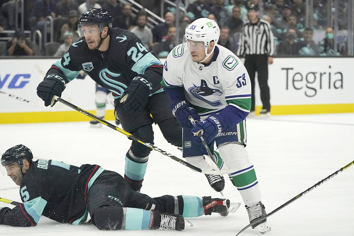Vancouver Canucks centre Bo Horvat (53) watches his goal hit the net, next to Seattle Kraken defencemen Jamie Oleksiak (24) and Mark Giordano (5) during the second period of an NHL hockey game Saturday, Oct. 23, 2021, in Seattle. (AP Photo/Ted S. Warren)