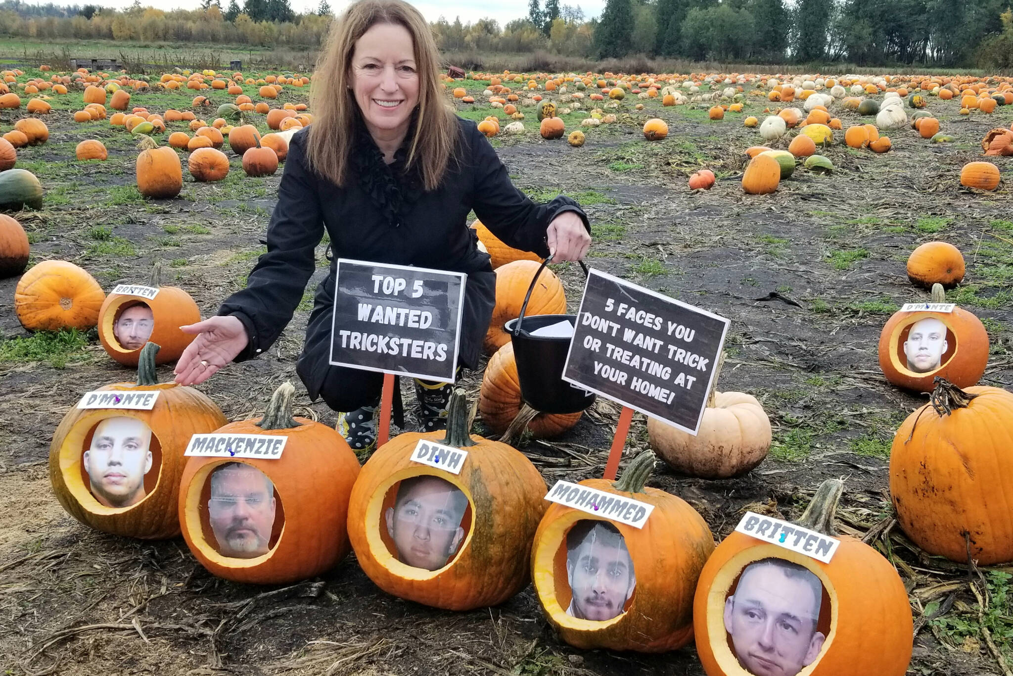 Linda Annis, executive director of Metro Vancouver Crime Stoppers, poses with photo cutouts in pumpkins of the top five wanted tricksters. (Submitted photo: Crime Stoppers)
