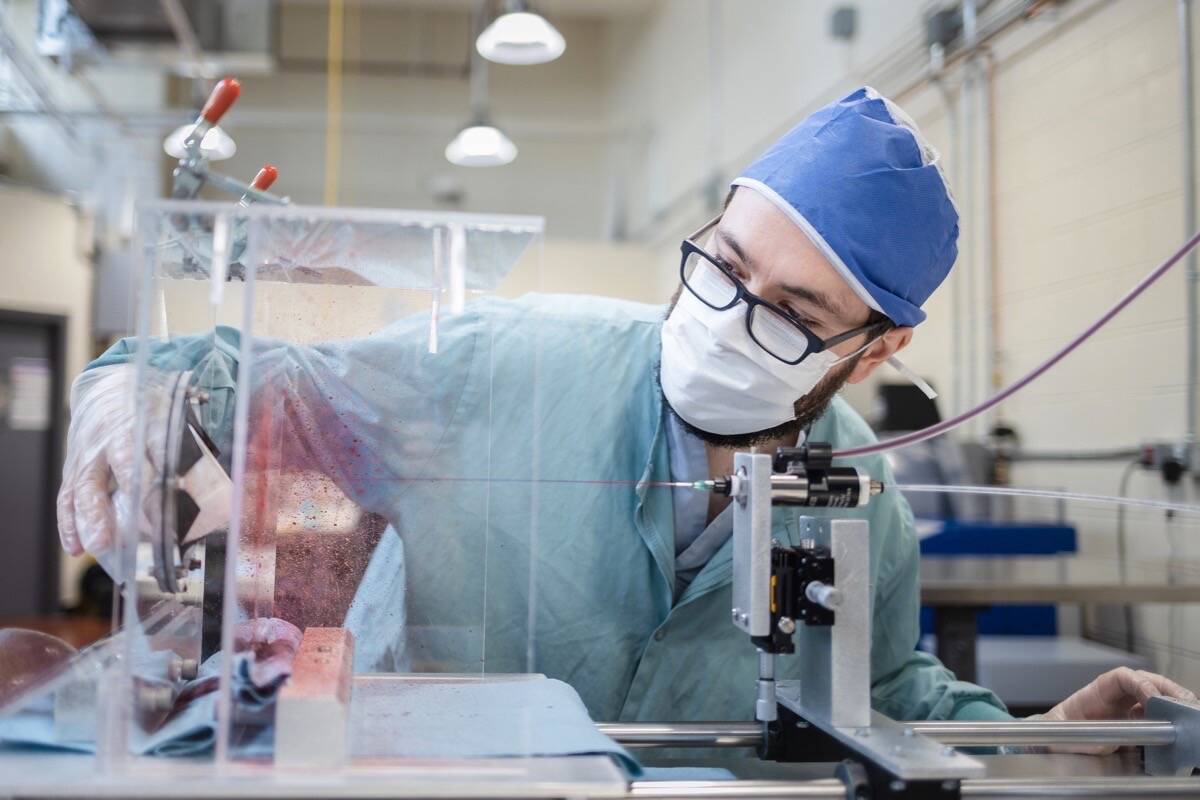 Technician tests personal protective equipment material at a lab at Vancouver General Hospital, the only accredited testing facility in Western Canada. (B.C. government photo)