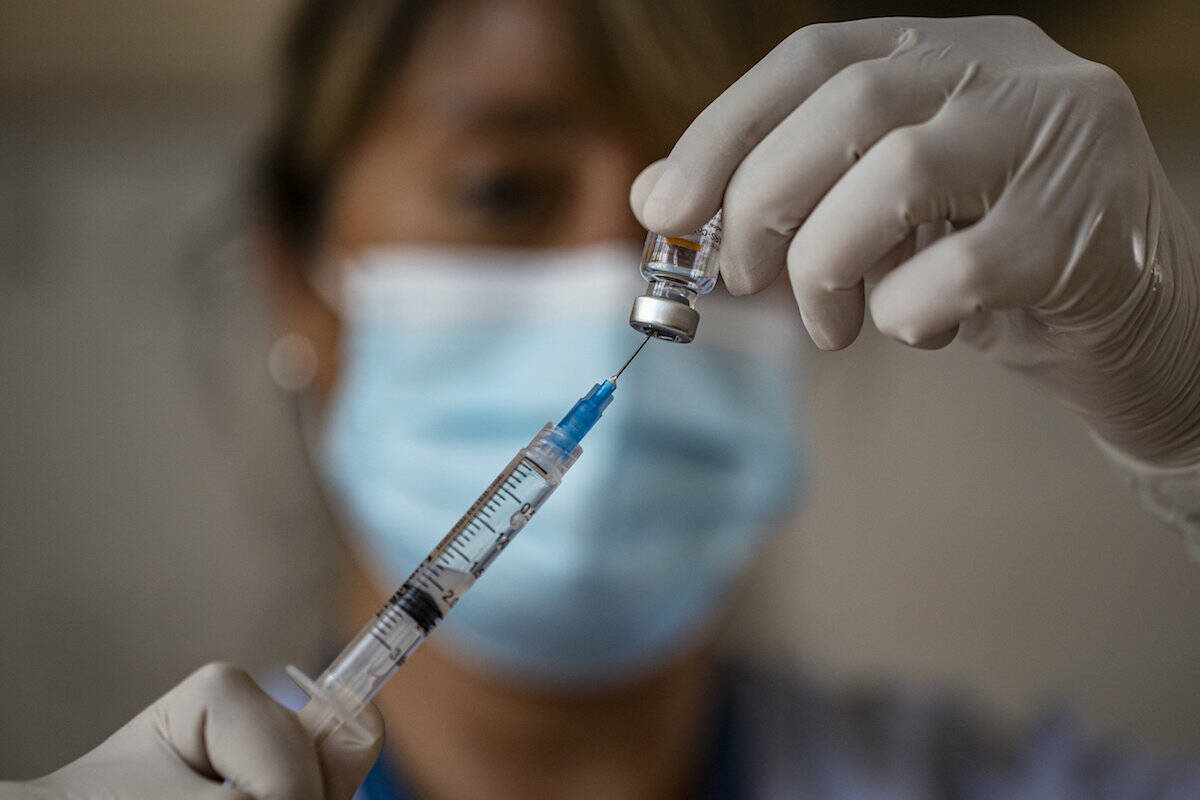 A health worker prepares shots of the vaccine for COVID-19. (AP Photo/Esteban Felix)