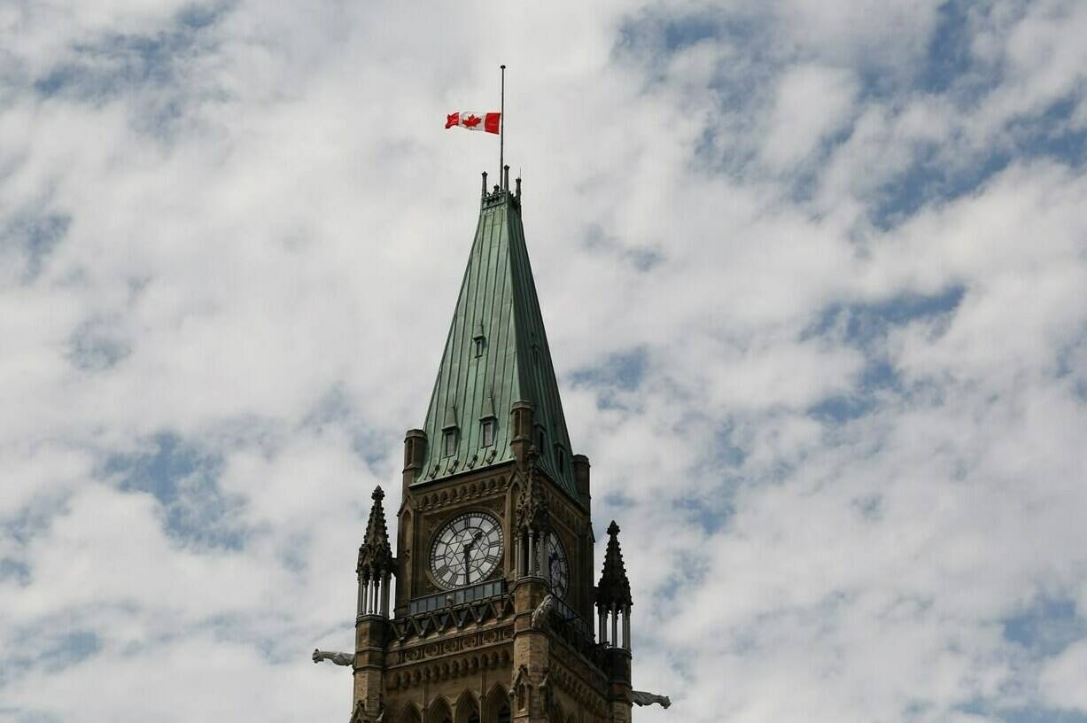 Heritage Canada says the national flag will remain at half-mast leading up to Remembrance Day instead of hoisting it up to be lowered again. The Canadian flag flies at half-mast on the Peace Tower at Parliament Hill on Canada Day in recognition of the discovery of unmarked graves of Indigenous children at residential schools. Thursday, July 1, 2021. THE CANADIAN PRESS/ Patrick Doyle