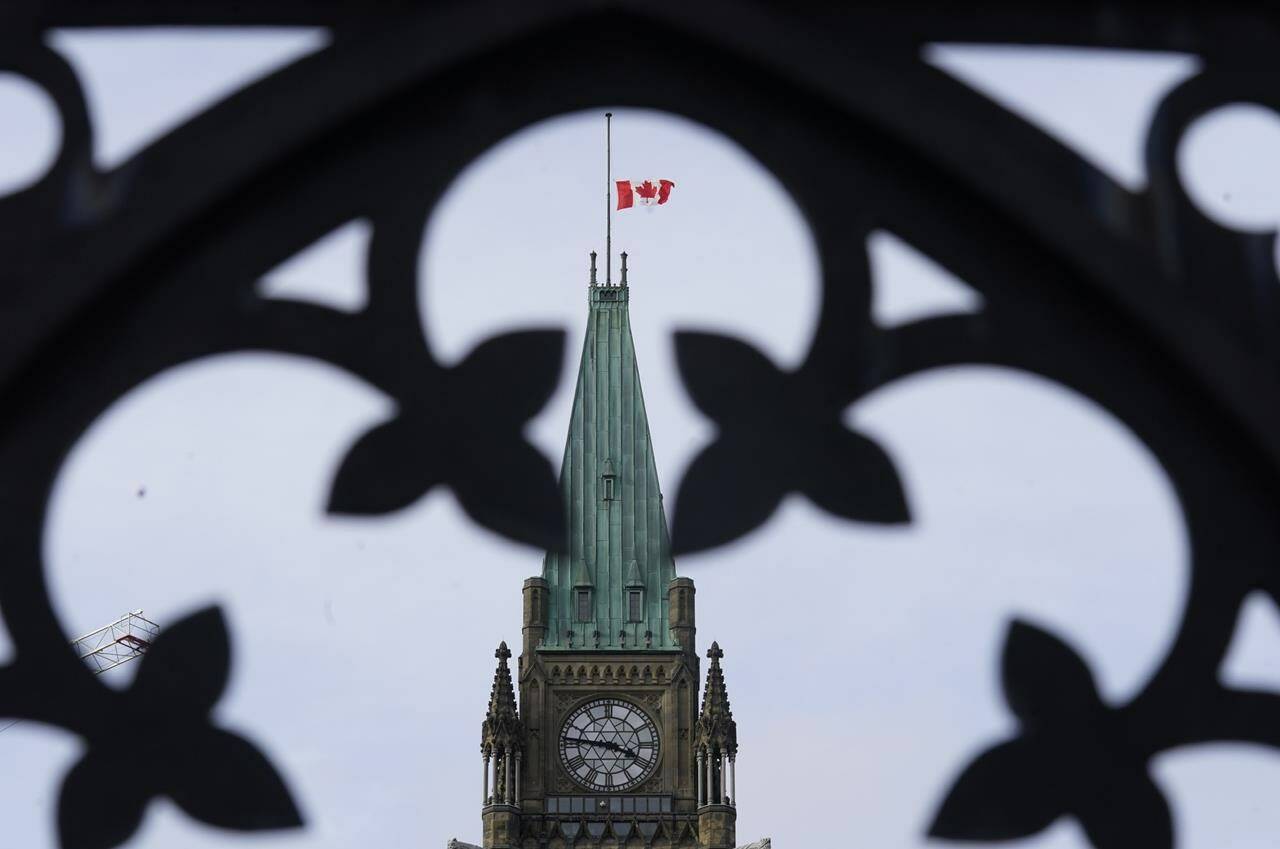 The Canadian flag flies at half mast over the Peace tower and parliament buildings Friday, Oct. 22, 2021. The national chief of the Assembly of First Nations says if Canada wants to raise its flag there needs to be another symbolic gesture made to recognize the genocide of Indigenous children. THE CANADIAN PRESS/Adrian Wyld