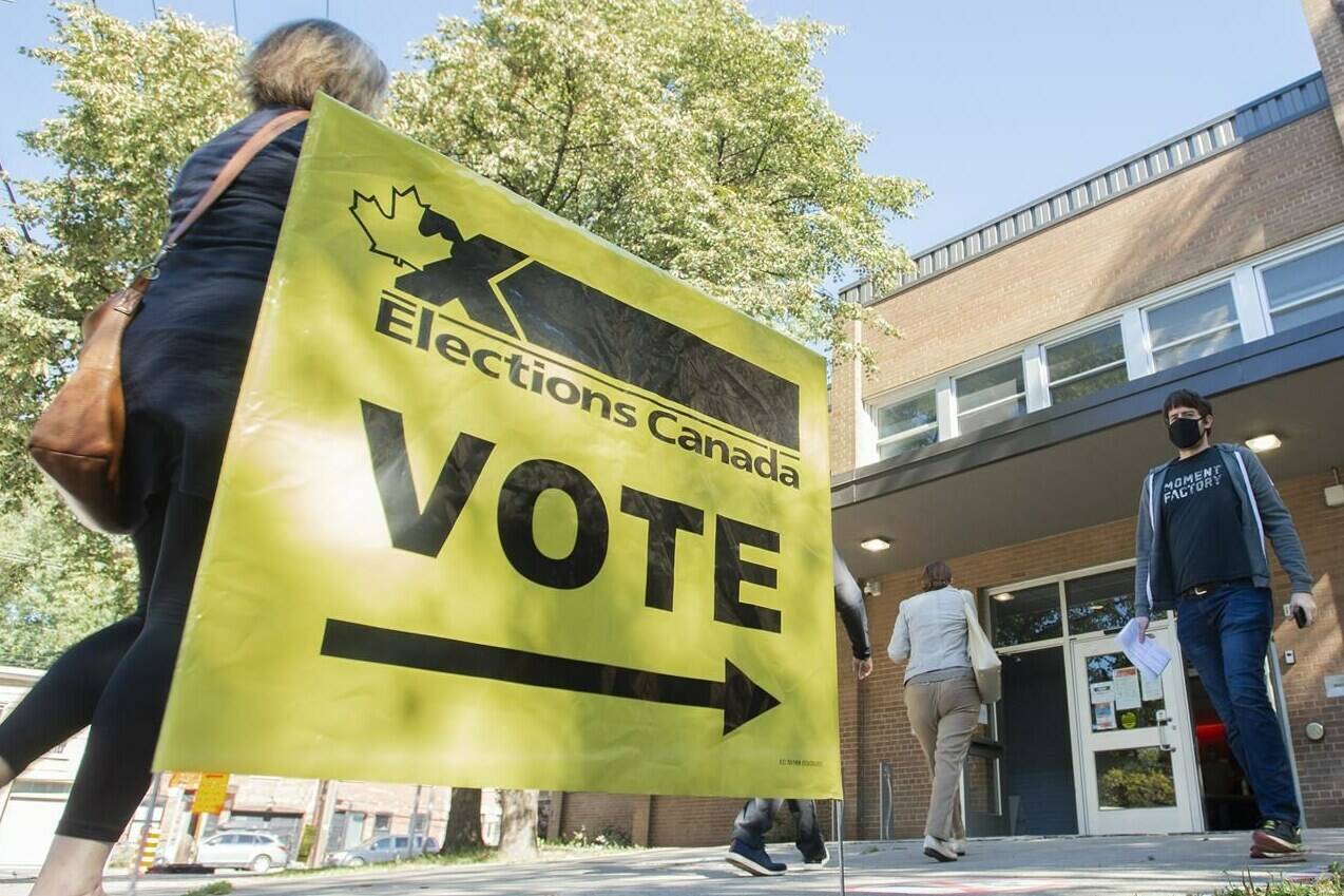 People arrive to cast their ballot on federal election day in Montreal, Monday, Sept. 20, 2021. Elections Canada was curious to know how many Canadians believed in conspiracy theories leading up to the recent federal vote. THE CANADIAN PRESS/Graham Hughes