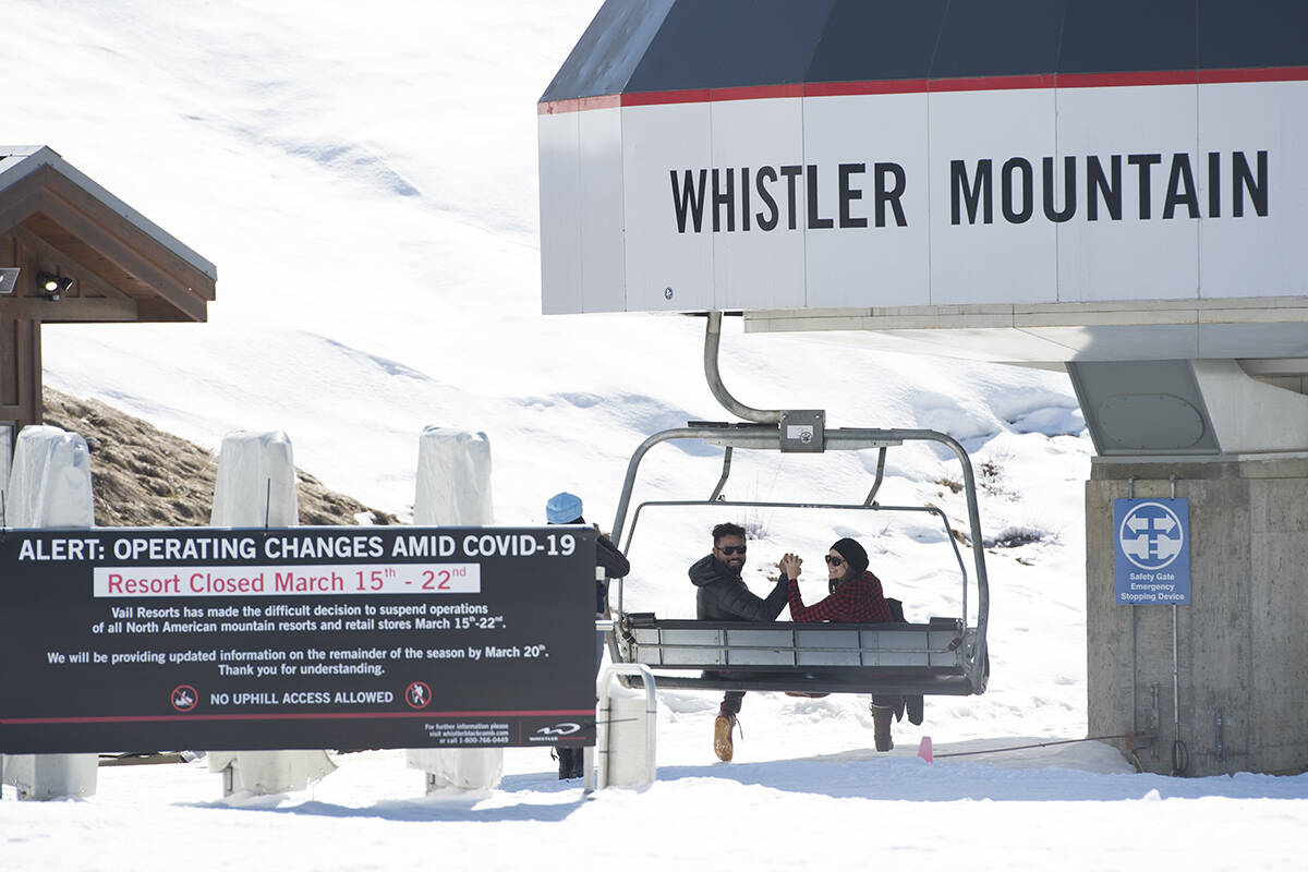 Tourists pose for photos at the base of Whistler Mountain in Whistler, B.C. Sunday, March 15, 2020. The Whistler Blackcomb resort which is owned by Vail Resorts shut down operations Saturday due to the ongoing COVID-19 crisis taking place worldwide. THE CANADIAN PRESS/Jonathan Hayward
