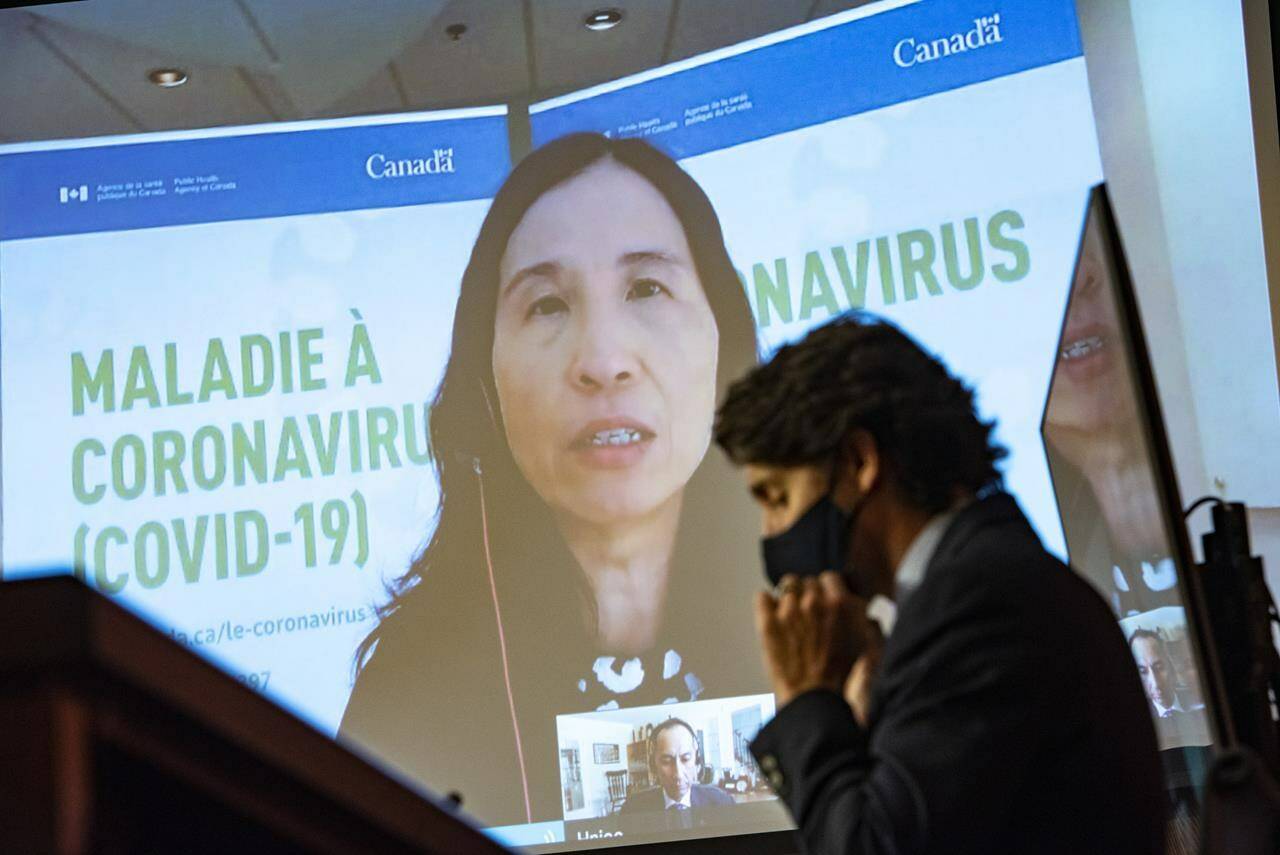 Prime Minister Justin Trudeau puts on a mask as he listens to Chief Public Health Officer of Canada Dr. Theresa Tam speak via video during a news conference on the COVID-19 pandemic, in Ottawa, Friday, March 12, 2021. THE CANADIAN PRESS/Justin Tang