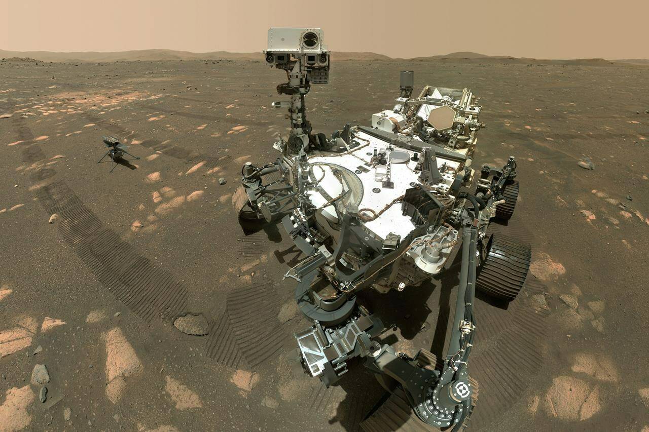 This image made available by NASA shows the Perseverance Mars rover, foreground, and the Ingenuity helicopter behind. Do you know the length of a solar day on the plante Mars? (NASA/JPL-Caltech/MSSS via AP)