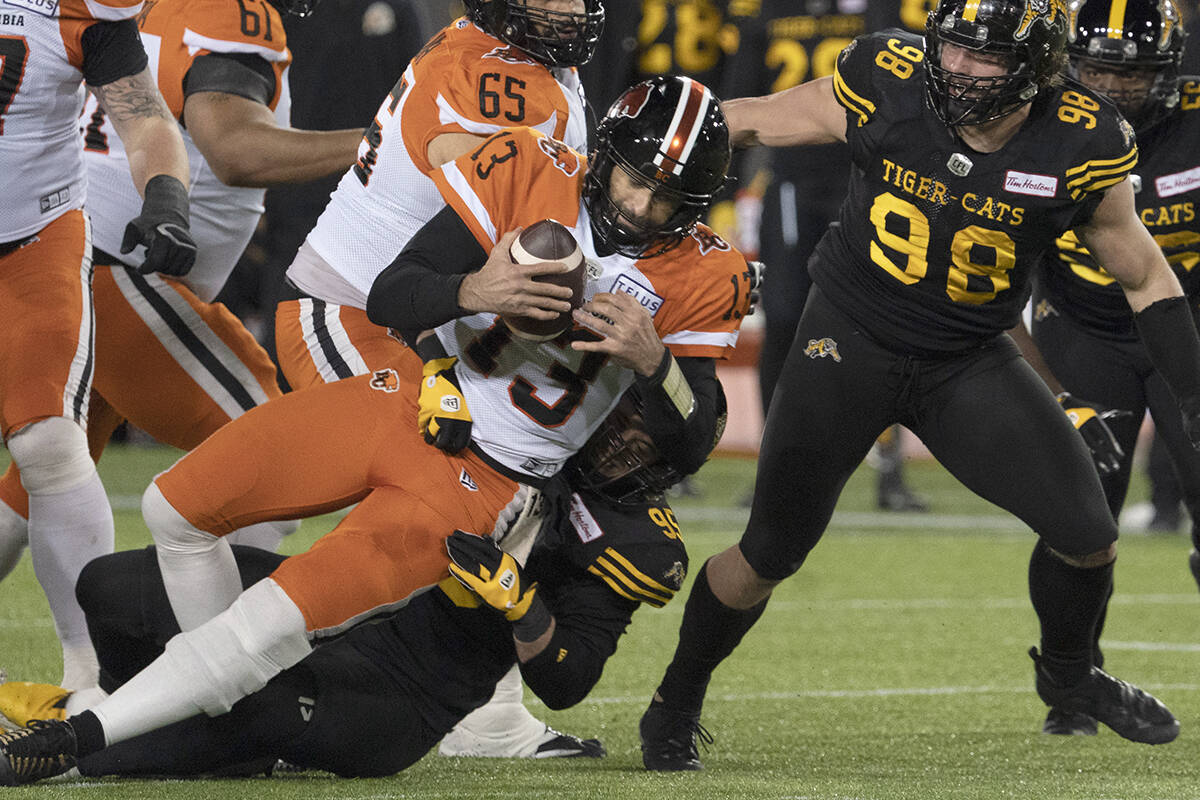 BC Lions quarterback Michael Reilly is sacked by Hamilton Tiger Cats defensive end Julian Howsare (95) during first half CFL football game action in Hamilton, Ont. on Friday, November 5, 2021. THE CANADIAN PRESS/Peter Power
