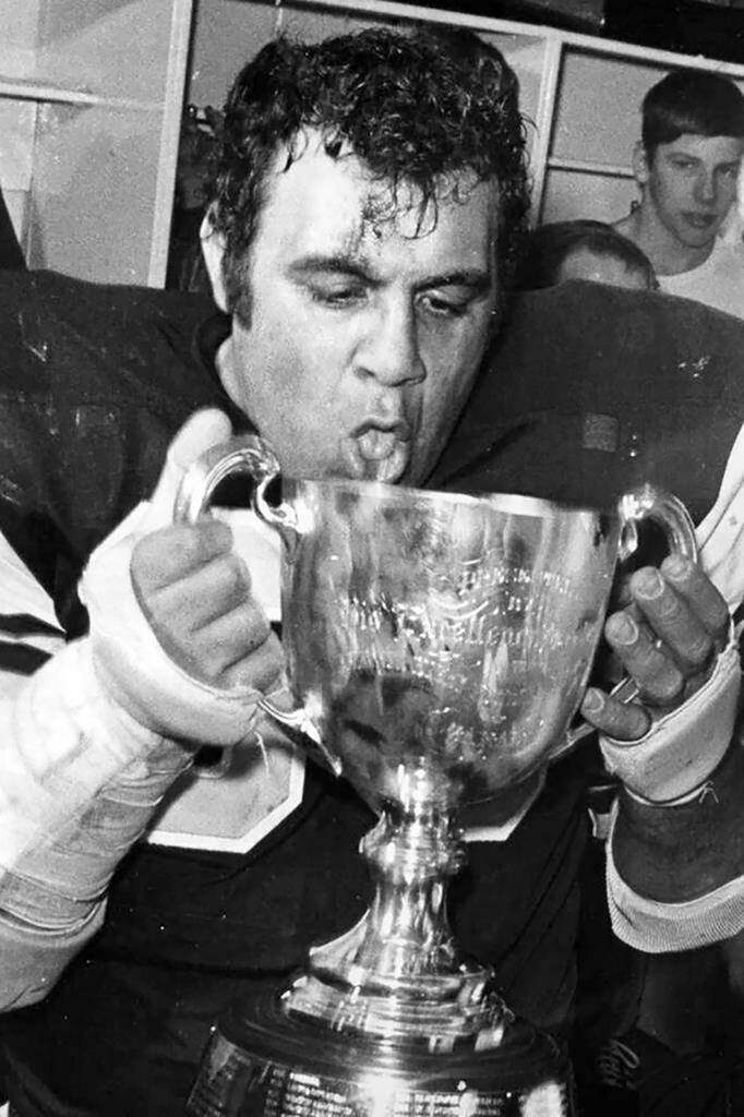 FILE - Hamilton Tiger-Cats tackle Angelo Mosca drinks from the Grey Cup after beating Saskatchewan for the Canadian Football League title in Vancouver, Dec. 3, 1972. Mosca, the five-time Grey Cup champion defensive lineman best remembered for a controversial hit and a subsequent fight with Joe Kapp 40 years later, died Saturday, Nov. 6, 2021. He was 84. (AP Photo/The Canadian Press, Chuck Stoody, File)