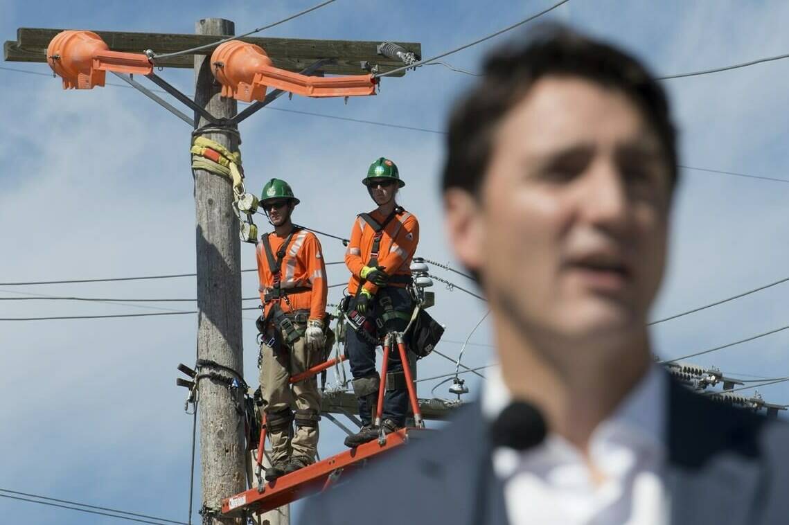 BC Hydro workers look on as Prime Minister Justin Trudeau makes an announcement at BC Hydro Trades Training Centre in Surrey, B.C., Thursday, August, 29, 2019. THE CANADIAN PRESS/Jonathan Hayward