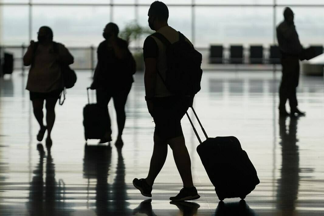 FILE - Travelers move through Salt Lake City International Airport Tuesday, Aug. 17, 2021, in Salt Lake City. The U.S. says that it’s inviting the global community to visit now that the government has ended the ban on travelers from 33 countries. In reality, however, it will still be difficult — if not impossible — for much of the globe to enter the country and experts say it will take years for travel to fully recover. (AP Photo/Rick Bowmer, file)