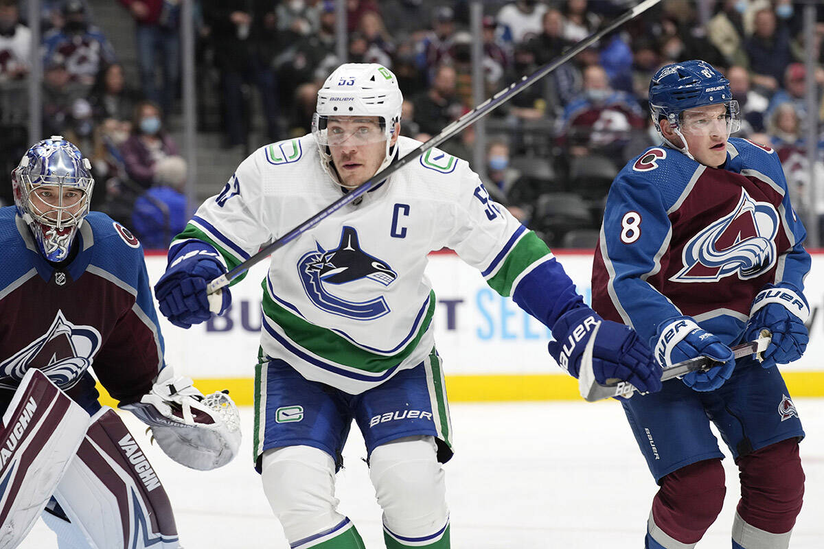 Vancouver Canucks centre Bo Horvat, centre, jostles for position with Colorado Avalanche defenceman Cale Makar, right, as goaltender Darcy Kuemper watches the puck during the second period of an NHL hockey game Thursday, Nov. 11, 2021, in Denver. (AP Photo/David Zalubowski)