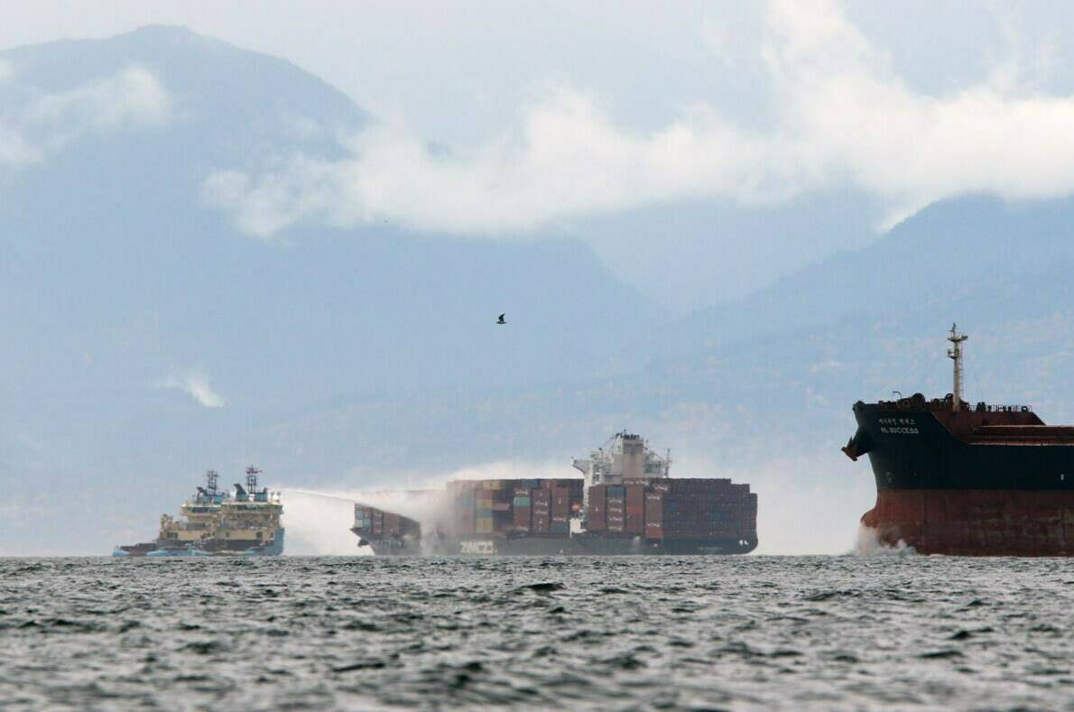 Ships work to control a fire onboard the MV Zim Kingston about eight kilometres from the shore in Victoria, B.C., on Sunday, October 24, 2021. THE CANADIAN PRESS/Chad Hipolito