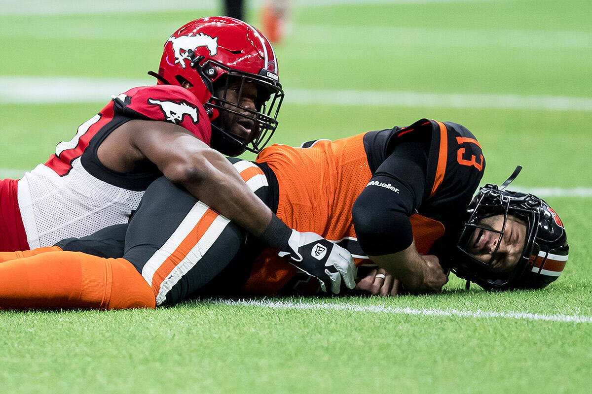 B.C. Lions quarterback Michael Reilly, right, hits the ground after Calgary Stampeders’ Shawn Lemon forced him to fumble the ball leading to a turnover during the second half of a CFL football game in Vancouver, on Friday, November 12, 2021. THE CANADIAN PRESS/Darryl Dyck