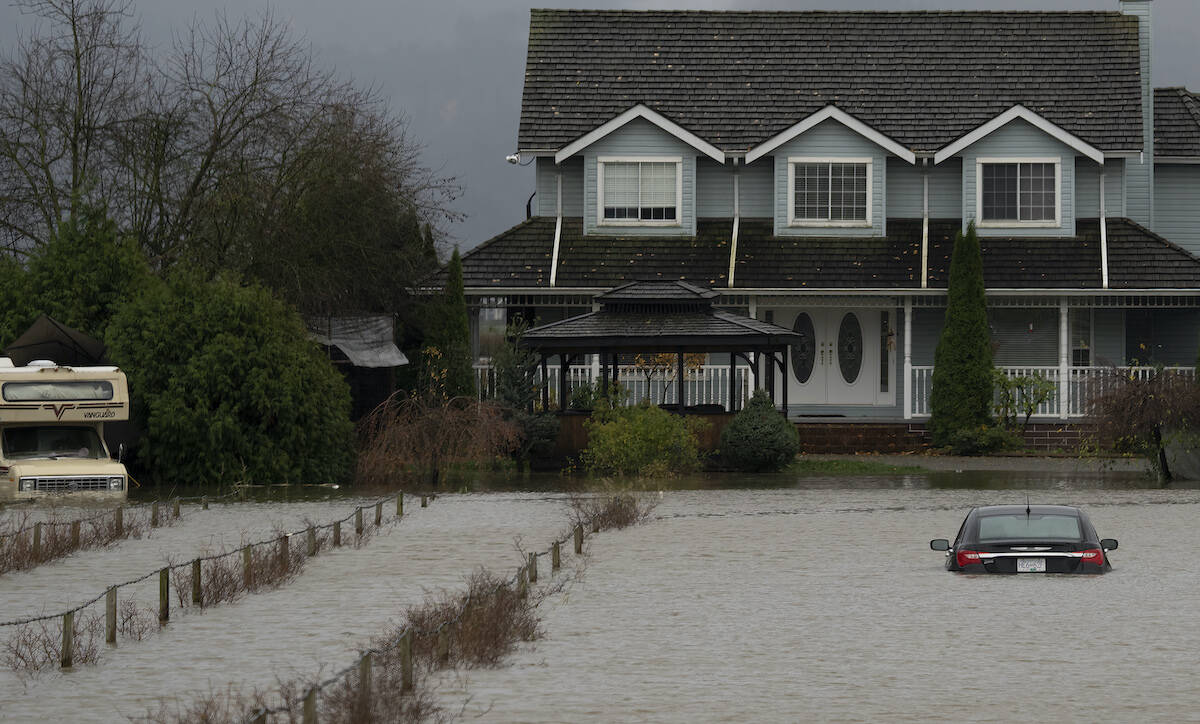 A vehicle is submerged in flood waters along a road in Abbotsford, B.C., Monday, Nov. 15, 2021. THE CANADIAN PRESS/Jonathan Hayward
