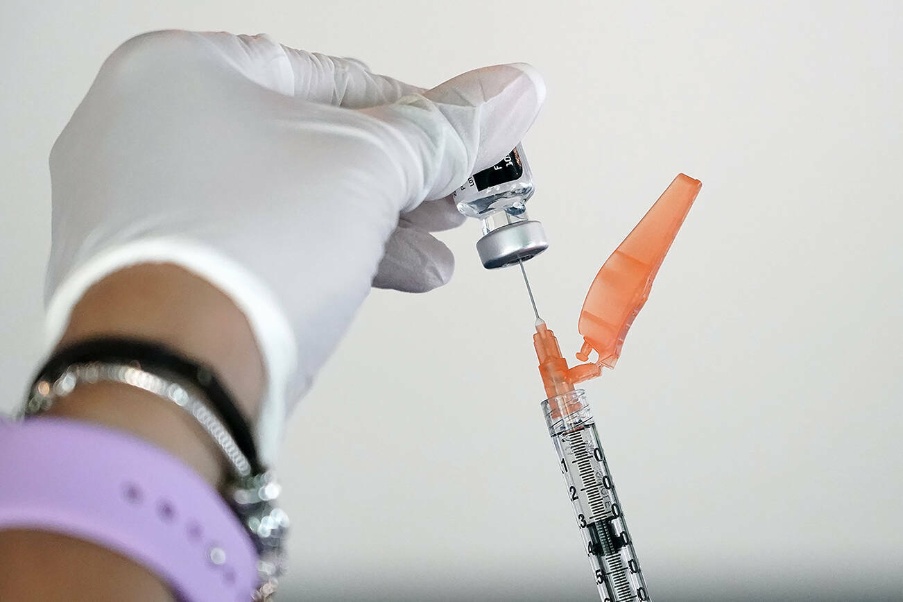 FILE – A nurse loads a syringe with the Pfizer COVID-19 vaccine in the U.S. (AP Photo/Rogelio V. Solis)