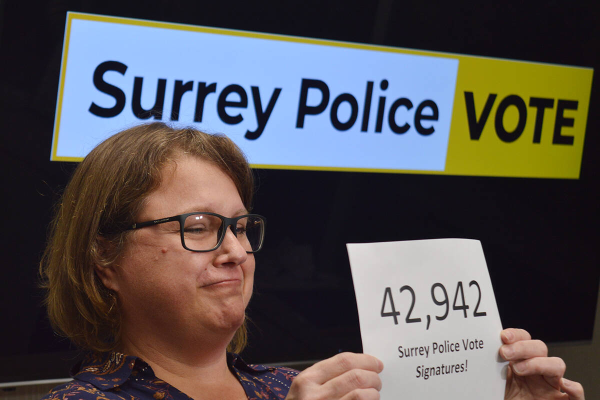 Darlene Bennett holds a piece of paper showing how many elgible Surrey voters signed the Surrey Police Vote petition. (Aaron Hinks photo)