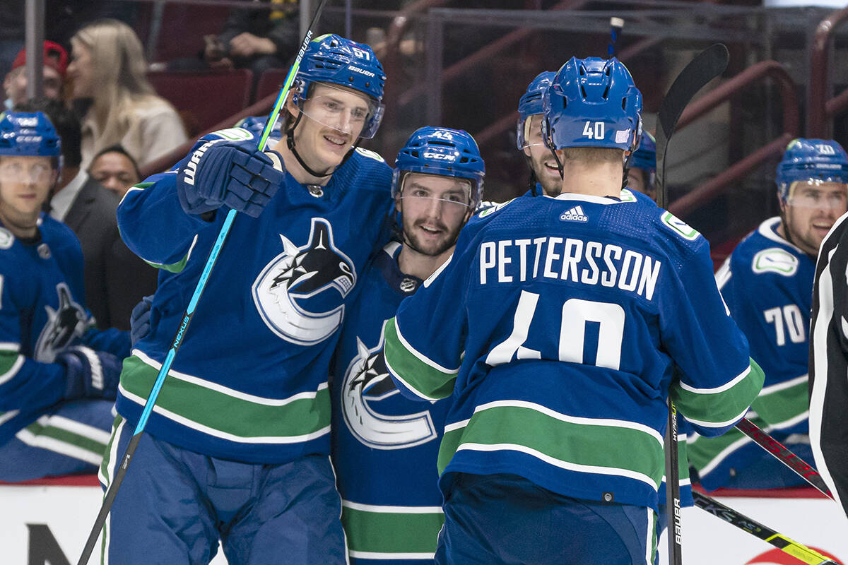 Vancouver Canucks’ Kyle Burroughs (middle) celebrates with teammates Tyler Myers (left) and Elias Pettersson after scoring a goal against the Winnipeg Jets during second period NHL hockey action in Vancouver, B.C., Friday, Nov. 19, 2021. THE CANADIAN PRESS/Rich Lam