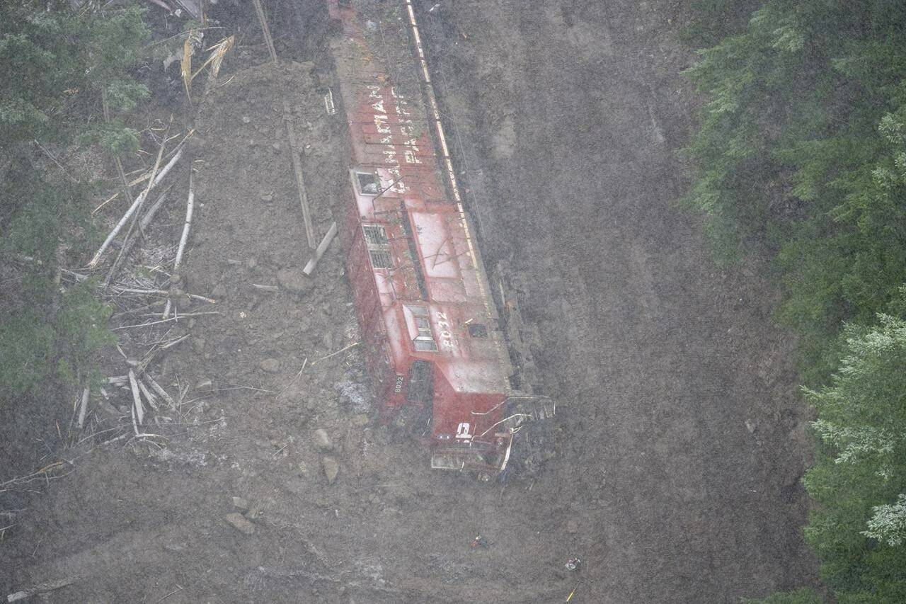 A Canadian Pacific locomotive and its cars that were knocked off of the train track by heavy rains and mudslides earlier in the week is pictured in the Fraser Canyon near Hope, B.C., Thursday, Nov. 18, 2021. CP Rail aims to restore service in B.C. next week after devastating mudslides. THE CANADIAN PRESS/Jonathan Hayward