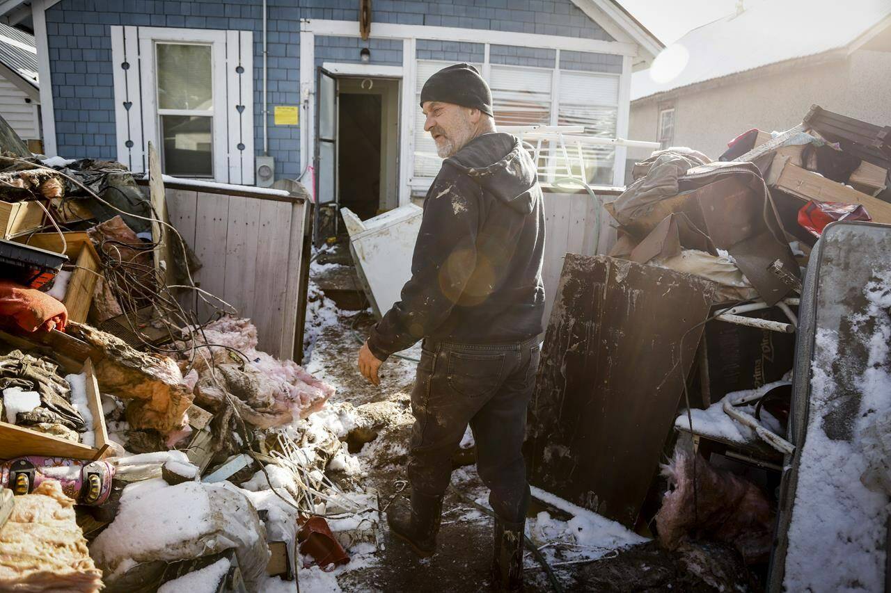 Mario Loutef cleans up after his home was flooded in Princeton, B.C., Saturday, Nov. 20, 2021.THE CANADIAN PRESS/Jeff McIntosh