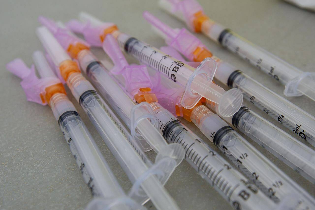 Several Moderna vaccine syringes lay on a table during a COVID-19 vaccine drive-thru clinic at Richardson Stadium in Kingston, Ont., Friday, May 28, 2021. After millions of Quebecers rolled up their sleeves for COVID-19 vaccines, it could soon be zoo animals’ turn to get the shot. THE CANADIAN PRESS/Lars Hagberg