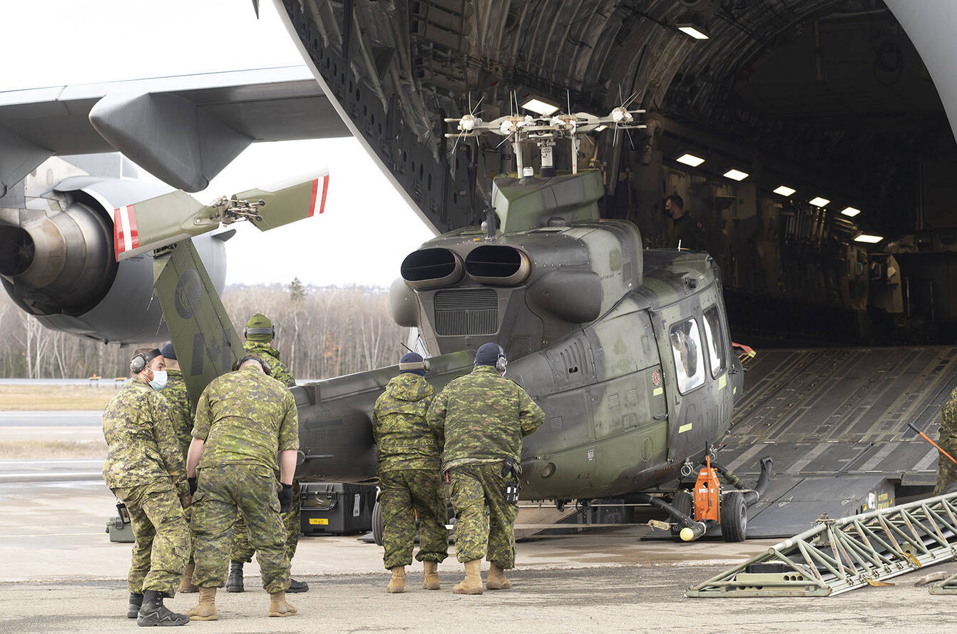A CH-146 Griffon helicopter is loaded on board a C-177 Globemaster III as the Canadian Armed Forces send relief to the floods in British Columbia, in Quebec City, Friday, Nov. 19, 2021. THE CANADIAN PRESS/Jacques Boissinot