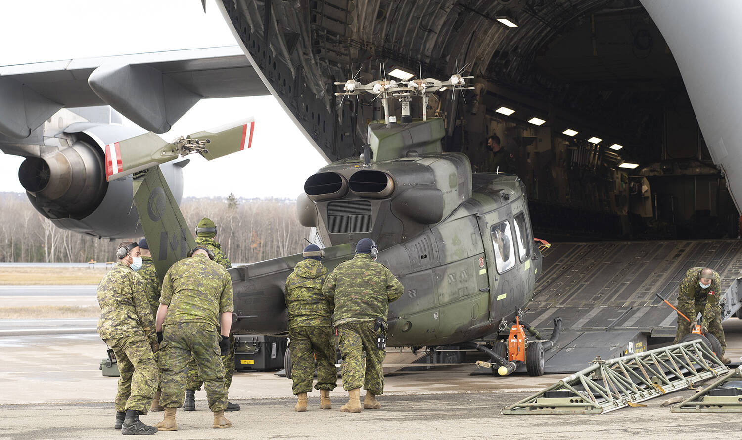 A CH-146 Griffon helicopter is loaded on board a C-177 Globemaster III as the Canadian Armed Forces send relief to the floods in British Columbia, in Quebec City, Friday, Nov. 19, 2021. THE CANADIAN PRESS/Jacques Boissinot