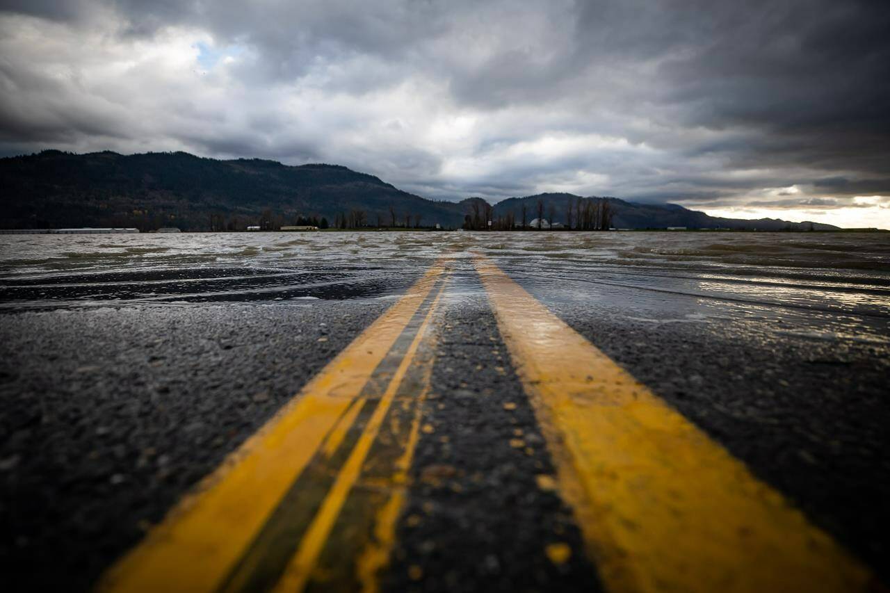 Floodwaters cover a road that runs through farmland in Abbotsford, B.C., Tuesday, Nov. 23, 2021. Heavy rains are flooding both the east and west coasts of Canada right now drawing attention to how ill prepared most of the country is for extreme weather. THE CANADIAN PRESS/Darryl Dyck