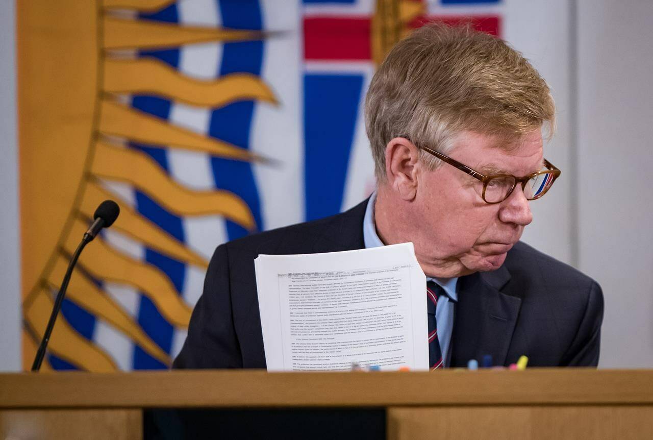 Commissioner Austin Cullen looks at documents before opening statements at the Cullen Commission of Inquiry into Money Laundering in British Columbia, in Vancouver, on Monday, Feb. 24, 2020. THE CANADIAN PRESS/Darryl Dyck