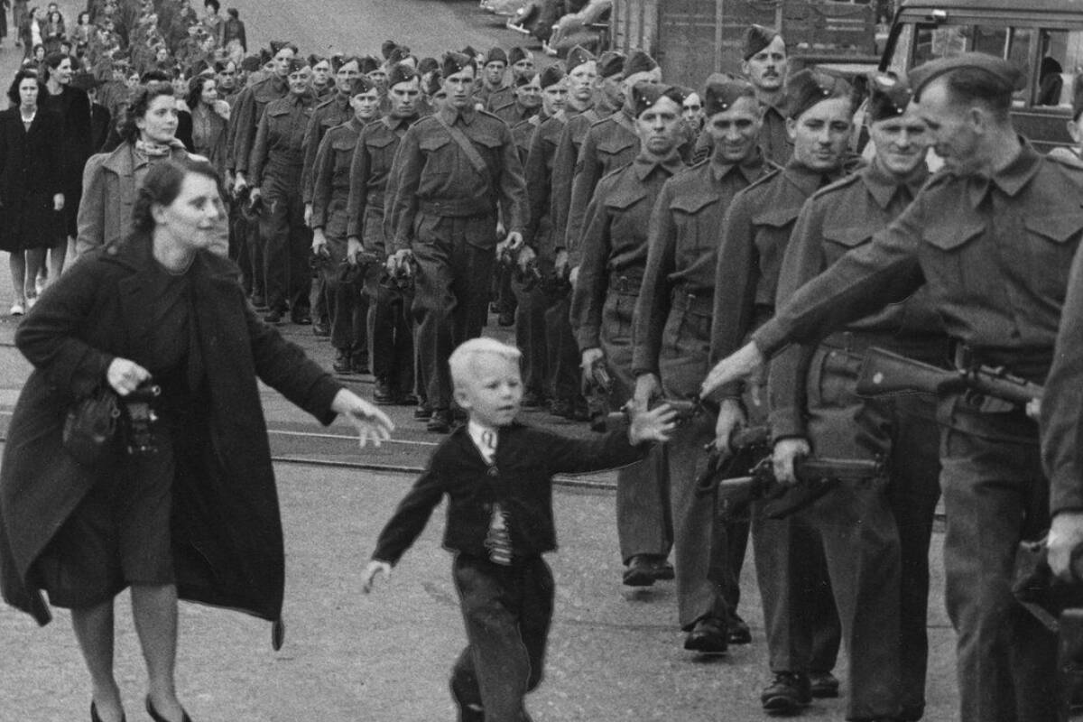 Lawrence Campbell’s father can be seen five soldiers behind the man reaching for his son. He has a gun strap visible across his chest. Photo: Claude P. Dettlof