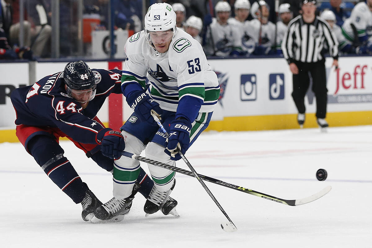 Columbus Blue Jackets’ Vladislav Gavrikov, left, knocks the puck away from Vancouver Canucks’ Bo Horvat during the first period of an NHL hockey game Friday, Nov. 26, 2021, in Columbus, Ohio. (AP Photo/Jay LaPrete)
