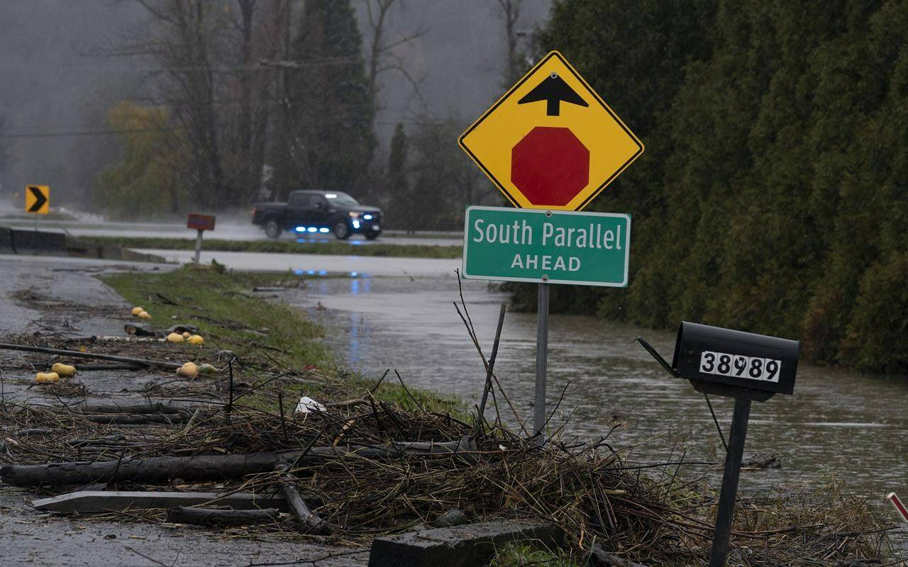 Debris is pictured along a flooded road in Abbotsford, B.C., Thursday, November 25, 2021. British Columbia’s Transportation Ministry is proactively closing several highways Saturday as another storm hammers the already-saturated south coast. THE CANADIAN PRESS/Jonathan Hayward
