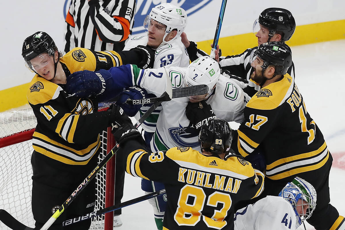 Boston Bruins’ Trent Frederic (11) scuffles with Vancouver Canucks’ Bo Horvat (53) and Luke Schenn (2) during the second period of an NHL hockey game, Sunday, Nov. 28, 2021, in Boston. (AP Photo/Michael Dwyer)