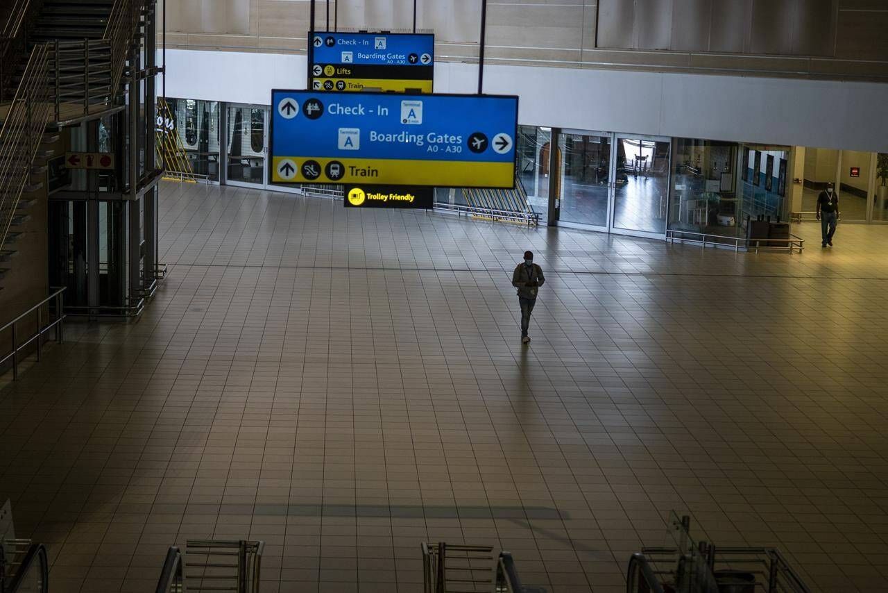 A man walks through a deserted part of Johannesburg’s OR Tambo’s airport, South Africa, Monday Nov. 29, 2021. The World Health Organisation urged countries around the world not to impose flight bans on southern African nations due to concern over the new omicron variant. THE CANADIAN PRESS/AP, Jerome Delay